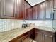 Close up of kitchen countertop featuring granite counters, dark wood cabinets and mosaic tile backsplash at 2687 Chantilly Ave, Kissimmee, FL 34741