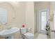 Bright bathroom with a pedestal sink, toilet, and glass-enclosed shower with access to the outside at 2926 Falconhill Dr, Apopka, FL 32712