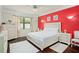 Comfortable bedroom with a large window, ceiling fan and red accent wall at 2926 Falconhill Dr, Apopka, FL 32712