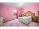 Pink bedroom with classic furniture, plush rug, teddy bears, and a view of the lush outdoors at 2926 Falconhill Dr, Apopka, FL 32712