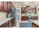 Modern kitchen featuring dark wood cabinets, stainless steel appliances, and light-colored countertops at 2926 Falconhill Dr, Apopka, FL 32712