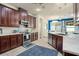 Well-lit kitchen featuring dark wood cabinets, stainless steel appliances, and tile floors at 2926 Falconhill Dr, Apopka, FL 32712