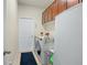 Bright laundry room with a front load washer, dryer and brown cabinets at 2926 Falconhill Dr, Apopka, FL 32712