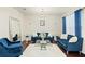 Formal living room with blue couches, a white rug, and a chandelier at 2926 Falconhill Dr, Apopka, FL 32712