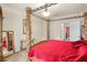 Elegant main bedroom featuring carved four poster bed with red quilted bedding and doorway to other rooms at 2926 Falconhill Dr, Apopka, FL 32712