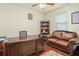 Home office with a large wooden desk, leather sofa, and ample natural light at 2926 Falconhill Dr, Apopka, FL 32712