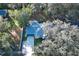 An aerial view of a well-maintained house with mature trees, a gray roof, and a well-manicured green lawn at 297 N Lake Jessup Ave, Oviedo, FL 32765