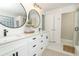 Bright bathroom featuring a double vanity, round mirrors and modern fixtures at 297 N Lake Jessup Ave, Oviedo, FL 32765