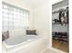 Serene bathroom with a soaking tub, glass block window, and a walk-in closet at 297 N Lake Jessup Ave, Oviedo, FL 32765