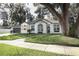 A charming home featuring a gray roof, light-colored brick, lovely landscaping, and an attached two-car garage at 297 N Lake Jessup Ave, Oviedo, FL 32765