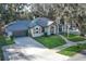 Charming one-story home features a gray roof, white brick, lovely landscaping, and an attached two-car garage at 297 N Lake Jessup Ave, Oviedo, FL 32765