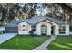 A well-maintained home exterior with a landscaped front yard, a stone walkway, and a two-car garage at 297 N Lake Jessup Ave, Oviedo, FL 32765