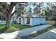 Charming home exterior with a brick driveway, manicured lawn, and mature trees at 297 N Lake Jessup Ave, Oviedo, FL 32765