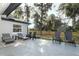 A large, concrete patio space with lounge seating, a rug, and wooden chairs overlooks the fenced backyard at 297 N Lake Jessup Ave, Oviedo, FL 32765