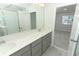 Modern bathroom featuring double sinks, quartz countertops, and a glass-enclosed shower at 3031 Pilot House Pl, Oviedo, FL 32765