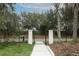 A gated entrance to the community with a sidewalk, landscaping, and metal fencing at 3031 Pilot House Pl, Oviedo, FL 32765