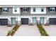 View of multiple townhomes showing driveways, garages, stone accents, and landscaping at 3031 Pilot House Pl, Oviedo, FL 32765