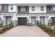 Townhome exterior with brick accents, a driveway, and a blue front door at 3031 Pilot House Pl, Oviedo, FL 32765