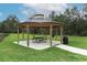 A community gazebo with a picnic table on a concrete platform, next to a lush green lawn at 3031 Pilot House Pl, Oviedo, FL 32765