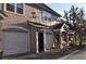 Exterior view of a two-story townhome with attached garages and brick paver street at 3307 Greenwich Village Blvd # 205, Orlando, FL 32835