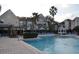 Community pool with lounge chairs, palm trees, and a gazebo at 3307 Greenwich Village Blvd # 205, Orlando, FL 32835