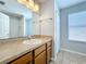 Well-lit bathroom featuring a neutral-toned vanity, mirror, and tiled floor at 4012 Longworth Loop, Kissimmee, FL 34744