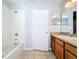 Full bathroom featuring a tub, sink, and tiled floor at 4012 Longworth Loop, Kissimmee, FL 34744