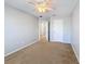 Cozy bedroom features neutral walls, plush carpet, a ceiling fan, and a doorway leading to another room at 4012 Longworth Loop, Kissimmee, FL 34744