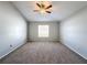 Cozy bedroom featuring plush carpet, neutral paint, a ceiling fan, and a window for ample natural light at 4012 Longworth Loop, Kissimmee, FL 34744