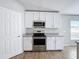 Close up of modern kitchen featuring stainless steel appliances, granite countertops and white cabinetry at 4012 Longworth Loop, Kissimmee, FL 34744