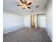 Main bedroom featuring carpet, a ceiling fan, vaulted ceilings, and a hallway leading to the en-suite bathroom at 4012 Longworth Loop, Kissimmee, FL 34744