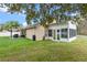 Expansive backyard with a covered patio, screened-in porch, and a lush green lawn at 4200 Bear Gully Rd, Winter Park, FL 32792