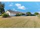 Expansive lawn behind the house with partial view of screened-in porch and fenced yard at 4520 Lake Gem Cir, Orlando, FL 32806