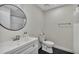 Bathroom featuring a round mirror, black floor tiles, and a tiled shower at 4520 Lake Gem Cir, Orlando, FL 32806