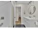 Bathroom with a round mirror, black floor tiles, and white subway tile in the shower at 4520 Lake Gem Cir, Orlando, FL 32806