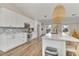 Contemporary white kitchen with a stylish backsplash and island seating at 4520 Lake Gem Cir, Orlando, FL 32806