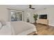 Bright main bedroom features a ceiling fan and television at 4520 Lake Gem Cir, Orlando, FL 32806