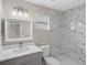 Bathroom featuring a modern vanity with granite top, and a marble-tiled shower, offering style and elegance at 4870 Oriole Dr, St Cloud, FL 34772