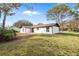 Back exterior view of modern white home with black trim and a well-manicured lawn at 4870 Oriole Dr, St Cloud, FL 34772