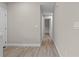 Hallway with wood-look floors, neutral walls, and access to other rooms, providing a seamless transition at 4870 Oriole Dr, St Cloud, FL 34772