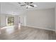 Spacious living room features wood-look flooring, a high ceiling with fan, and sliding glass doors to the outside at 4870 Oriole Dr, St Cloud, FL 34772