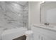 Bright bathroom features a marble-walled shower, white vanity, and modern fixtures at 501 Dean Creek Ln, Orlando, FL 32825