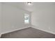 Bedroom featuring plush gray carpet, a window, and base trim at 501 Dean Creek Ln, Orlando, FL 32825