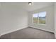 Bedroom featuring plush gray carpet, a window, and base trim at 501 Dean Creek Ln, Orlando, FL 32825