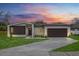 Modern single-story home with fresh lawn, long driveway, attached garage, and neutral paint scheme at dusk at 501 Dean Creek Ln, Orlando, FL 32825