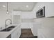 Bright kitchen features white cabinets, stainless steel microwave, quartz countertops and a modern faucet at 501 Dean Creek Ln, Orlando, FL 32825