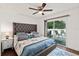 Comfortable main bedroom with a tufted headboard, ensuite, ceiling fan, and sliding glass door to outdoor deck at 516 8Th St, Orlando, FL 32820