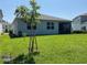 Spacious backyard featuring a lush lawn, young trees, and a screened-in lanai perfect for outdoor relaxation at 5179 Royal Point Ave, Kissimmee, FL 34746