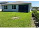 Backyard view with a lush lawn and a screened-in patio area at 5179 Royal Point Ave, Kissimmee, FL 34746