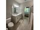 Well-lit bathroom featuring double sinks, granite countertops, and access to the bedroom at 5179 Royal Point Ave, Kissimmee, FL 34746